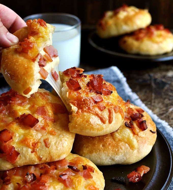 Pulling a chunk from a pile of Double Cheese and Bacon Rolls