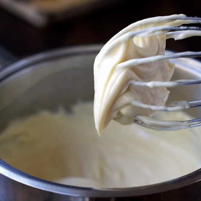 Closeup of whisk with Cheese Sauce for Bacon Wrapped Hot Dogs
