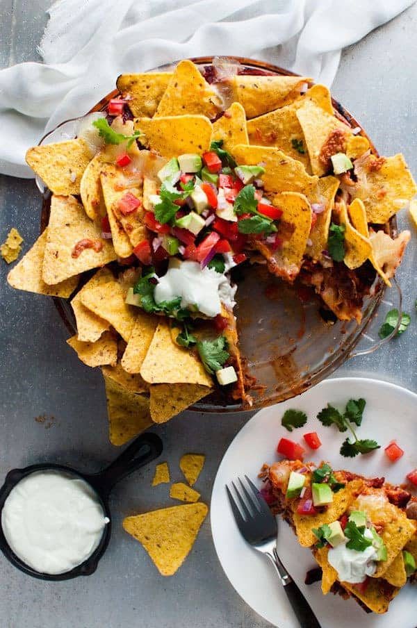 Nachos Pie topped with salsa, served with extra sour cream