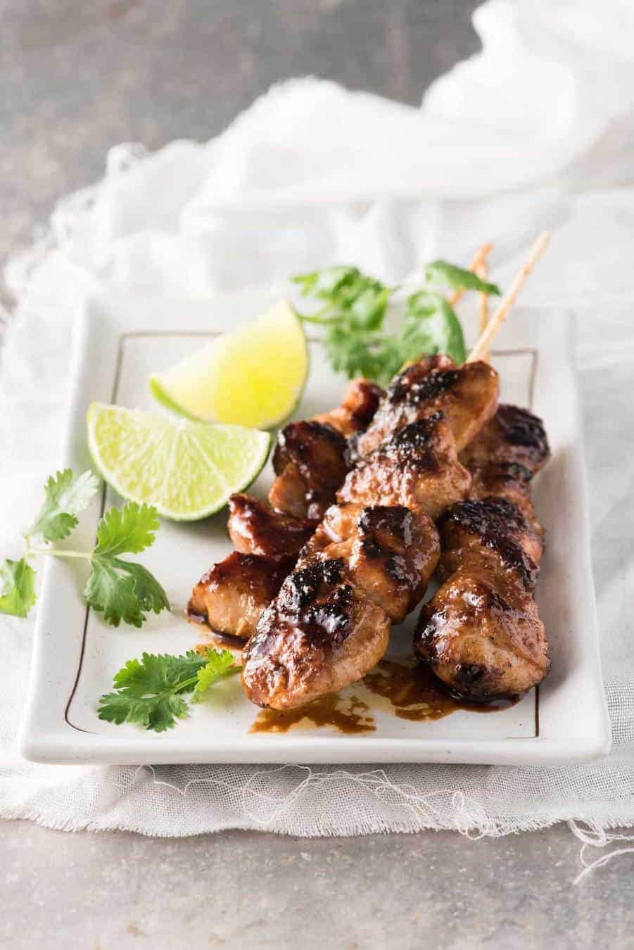 Three Honey Sriracha Chicken Skewers on a white rectangle plate.