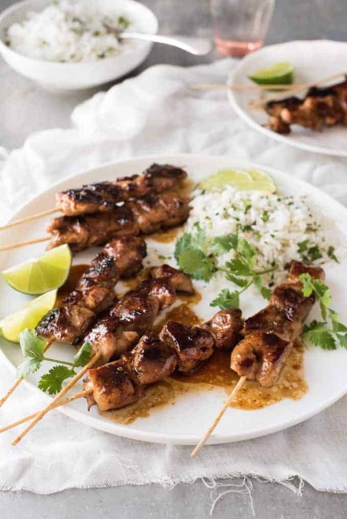 Honey Sriracha Chicken Skewers on a white plate with a side of coconut lime cilantro rice.