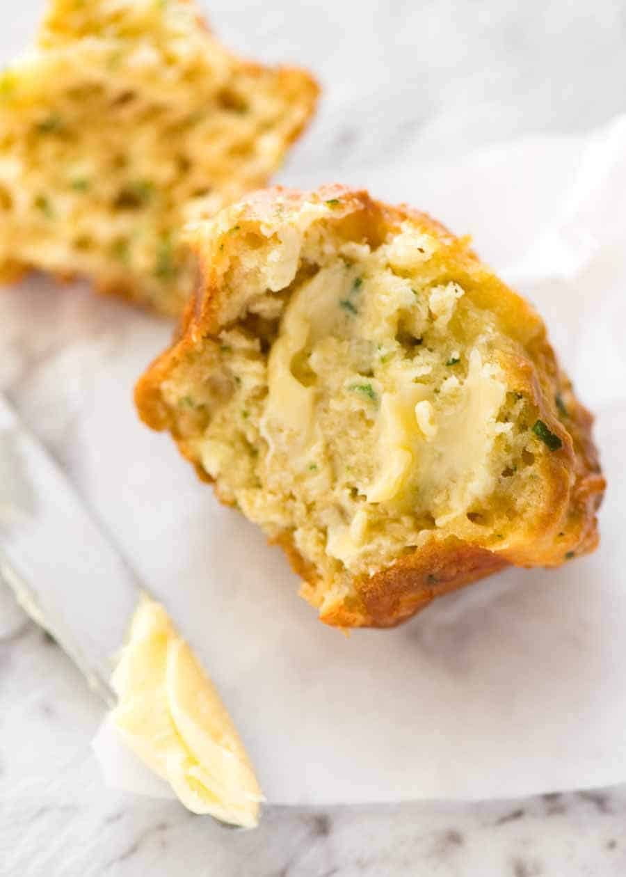 Half a Savoury Cheese Muffin smeared with butter, slowly melting.