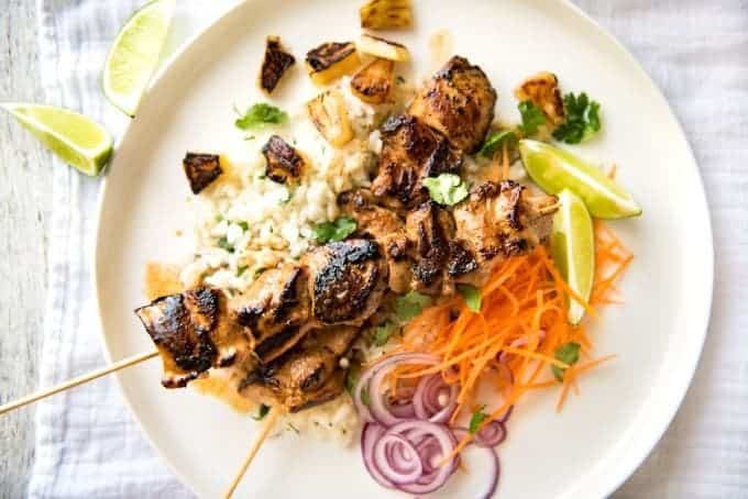 Pineapple Coconut Hawaiian Chicken Skewers on a white plate on top of coconut lime rice.