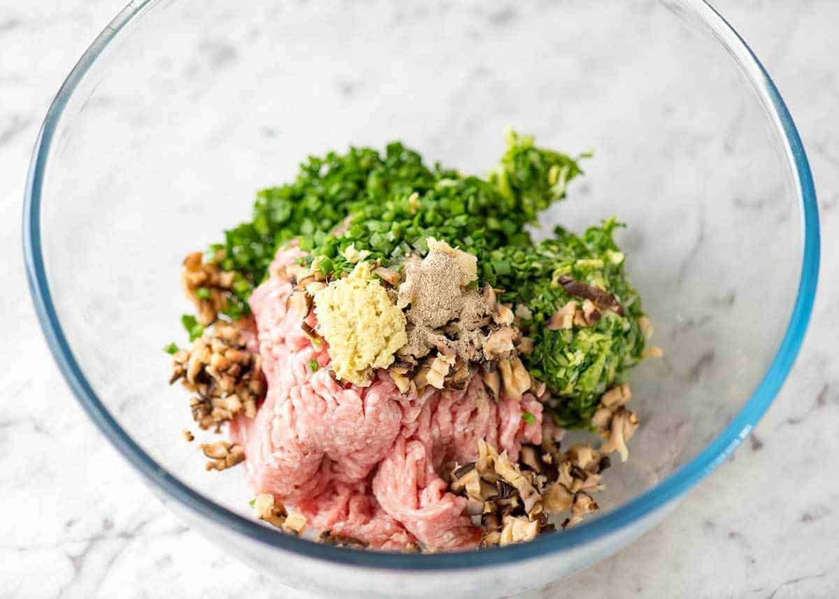 Glass bowl with Potsticker Filling made with pork, cabbage, shiitake mushrooms and chives.
