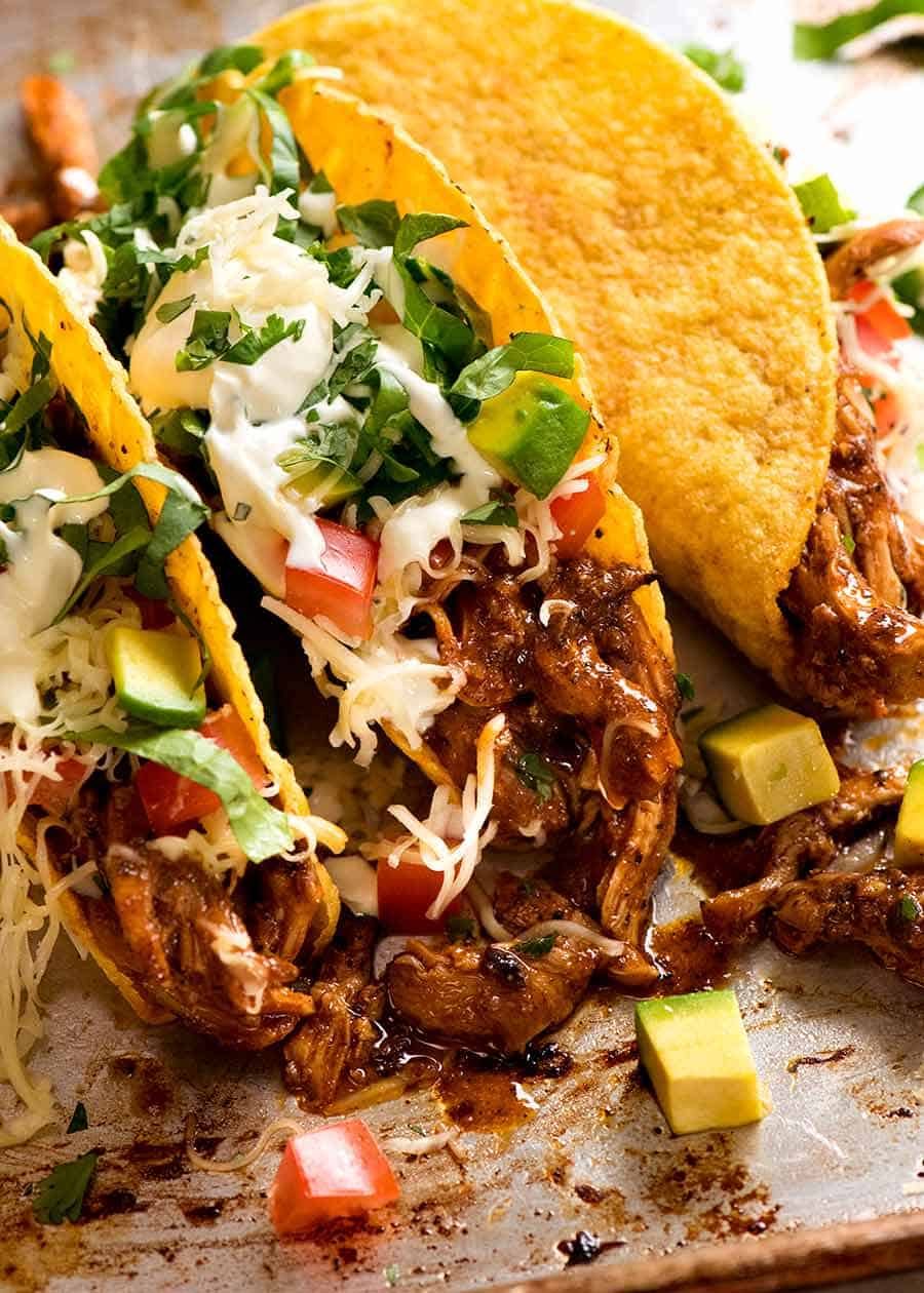 Three crisp corn taco shell stuffed with juicy Chicken taco filling, topped with avocado, tomato, onion, lettuce, cheese and sour cream