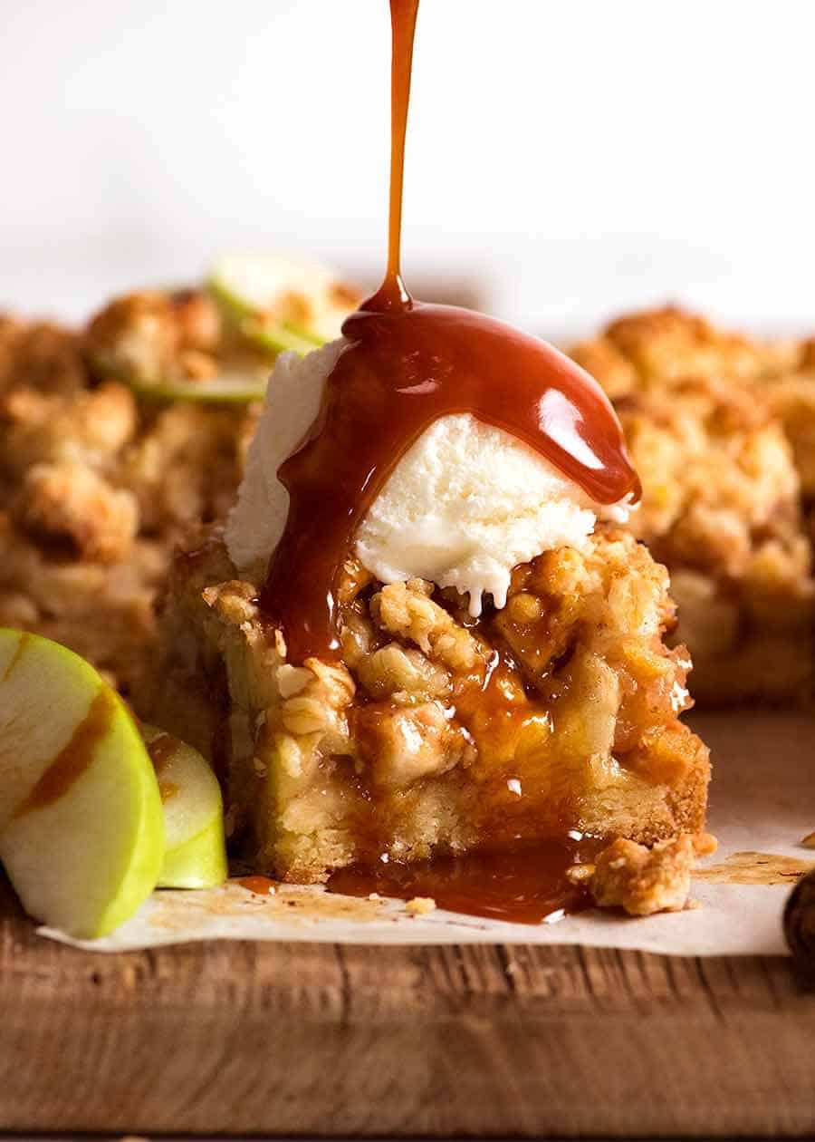 Apple Crumble Bars with ice cream and salted caramel sauce being drizzled over