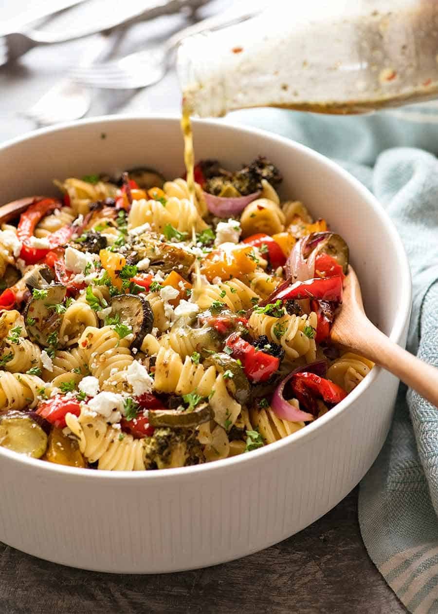 Pouring lemon garlic pasta salad dressing over Vegetable Pasta Salad