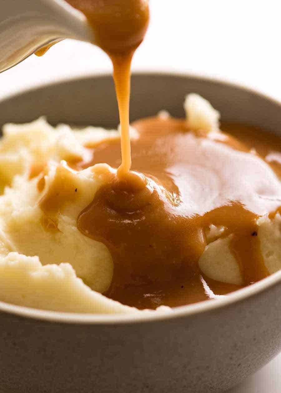 Pouring gravy over mashed potato