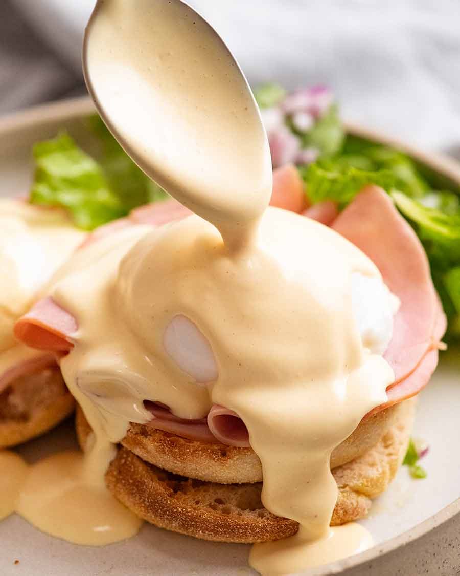 Pouring Hollandaise Sauce over Eggs Benedict