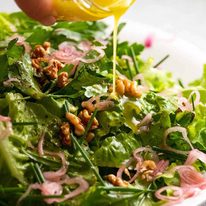 Drizzling lemon dressing over French Bistro Salad